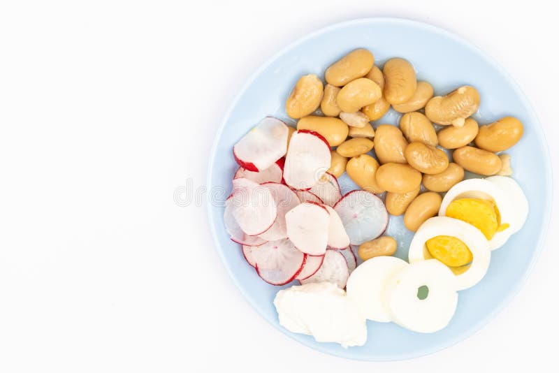 Salad med skivade kokta ägg, kokta bönor, skivade radisor och surgrädde arkivbild Salad med skivade kokta ägg, kokta bönor, skivade radisor och surgrädde arkivbild