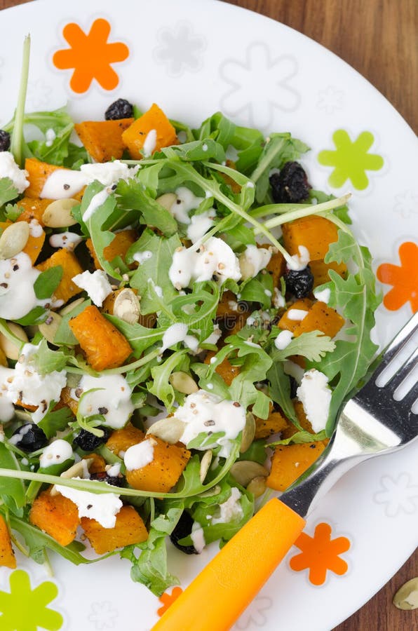 Salad with pumpkin, feta, arugula on a plate