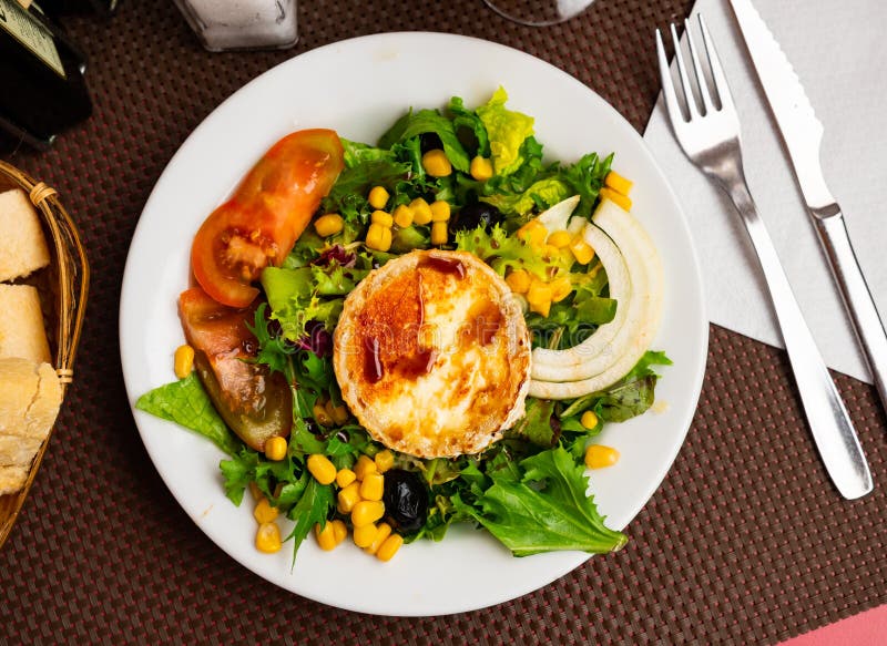 Salad with toasted soft cheese from goat milk with fresh vegetables, corn and nuts royalty free stock photos