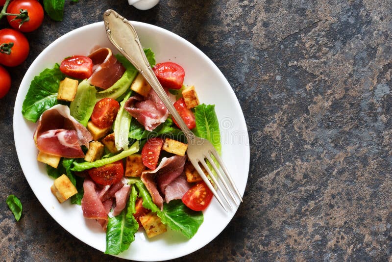 Salad with Tomatoes, Prosciutto and Grilled Cheese on a Stone
