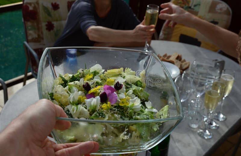 Salada de primavera com flores e sementes numa taça transparente. imagem de stock royalty free
