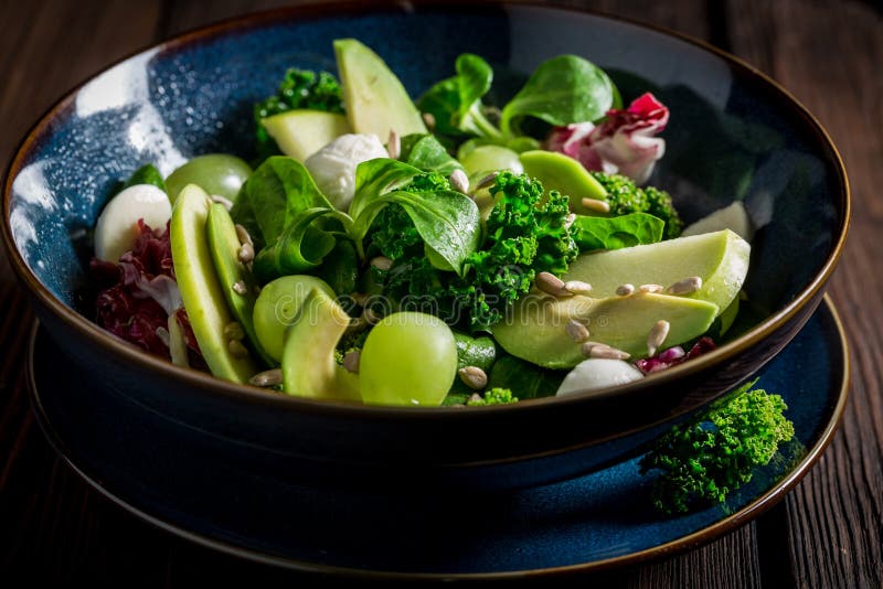 Salada fresca da couve com abacate, alface e uva imagem de stock Salada fresca da couve com abacate, alface e uva imagem de stock