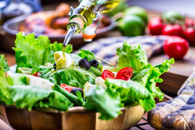 Vegetable lettuce salad. Olive oil pouring into bowl of salad. Italian Mediterranean or Greek cuisine. Vegetarian vegan food. Vegetable lettuce salad. Olive oil pouring into bowl of salad. Italian Mediterranean or Greek cuisine. Vegetarian vegan food.