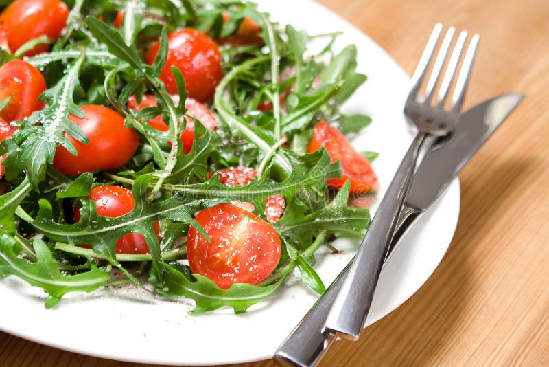 Salade avec des tomates et le rucola image libre de droits Salade avec des tomates et le rucola image libre de droits