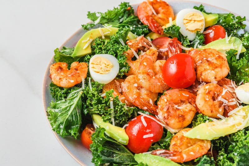 Salade César saine de crevettes avec les tomates et le kale's de parmesan d'avocat sur le fond blanc. Étroitement images libres de droits