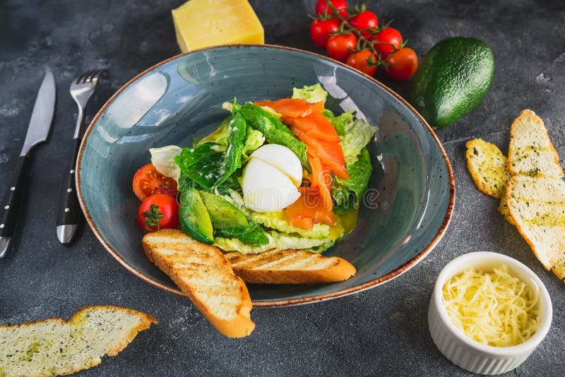 Salade de César avec l'oeuf, les saumons, l'avocat, les tomates-cerises et le pain grillé grillé, fin vers le haut de vue Nourrit photos libres de droits