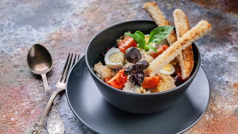 Salade de César en gros plan avec le poulet, l'oeuf de caille, les tomates-cerises, les croûtons et le basilic dans une cuvette b photographie stock