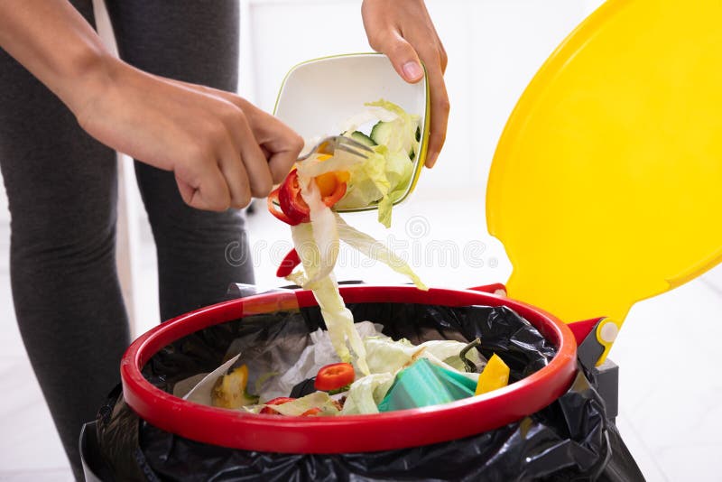 Salade de lancement de femme dans la poubelle