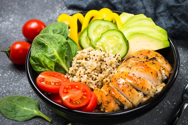 Salade de quinoa de cuvette de Bouddha avec le poulet et les légumes sur le noir images libres de droits Salade de quinoa de cuvette de Bouddha avec le poulet et les légumes sur le noir images libres de droits