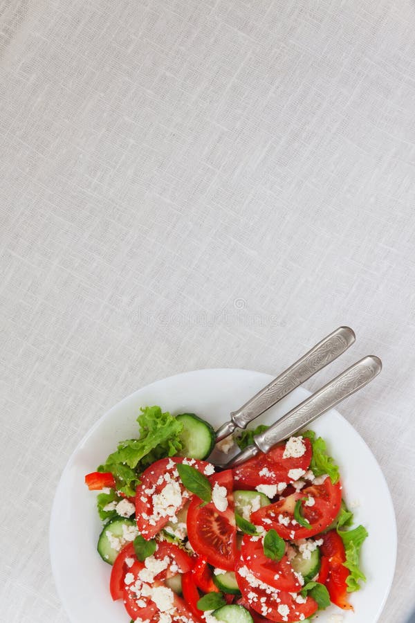 Salade de Shopska dans un plat blanc sur une nappe blanche Le concep photos stock Salade de Shopska dans un plat blanc sur une nappe blanche Le concep photos stock
