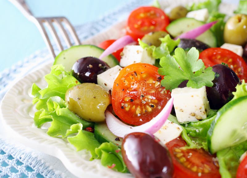 Delicious Greek salad with feta cheese, olives, tomato, cucumber and crispy lettuce garnished with chopped parsley. Delicious Greek salad with feta cheese, olives, tomato, cucumber and crispy lettuce garnished with chopped parsley