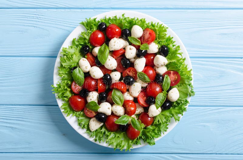 Salade met basilicum, tomaten, olijven en mozarella royalty-vrije stock afbeelding Salade met basilicum, tomaten, olijven en mozarella royalty-vrije stock afbeelding