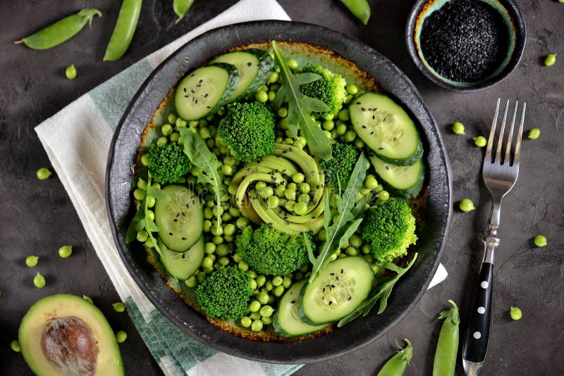 Salade saine de brocoli, de pois, de concombre et d'avocat avec l'arugula et l'huile d'olive Nourriture saine Vue supérieure images libres de droits Salade saine de brocoli, de pois, de concombre et d'avocat avec l'arugula et l'huile d'olive Nourriture saine Vue supérieure images libres de droits