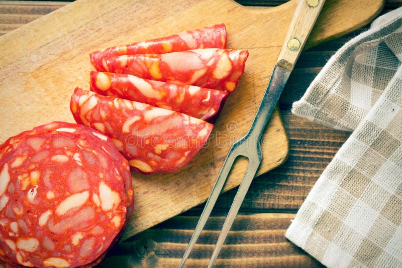Salame cortado do chouriço com forquilha fotos de stock royalty free Salame cortado do chouriço com forquilha fotos de stock royalty free