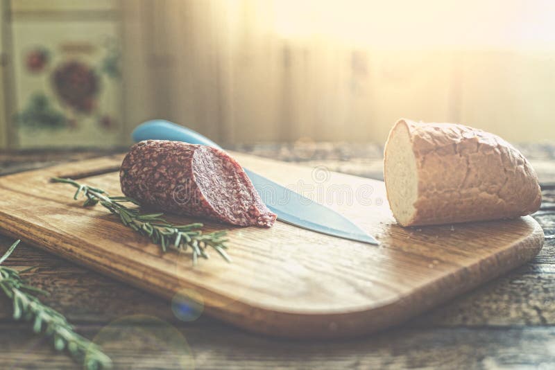 Salami, baguette, desayuno, mañana del verano, tabla de cocina, comida fotos de archivo libres de regalías Salami, baguette, desayuno, mañana del verano, tabla de cocina, comida fotos de archivo libres de regalías