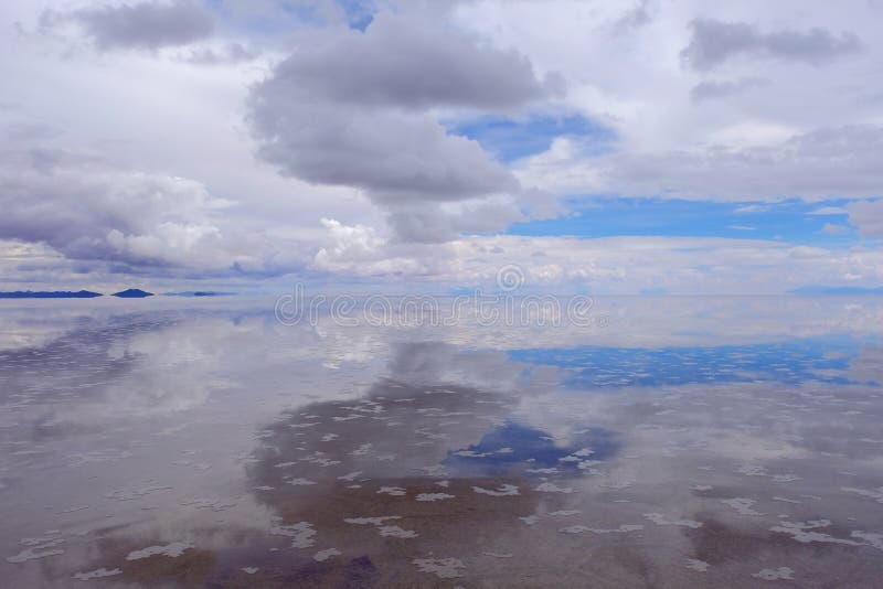 Salar de Uyuni, lago de sal plano con agua y las reflexiones hermosas del cielo nublado, Uyuni, Bolivia fotos de archivo libres de regalías Salar de Uyuni, lago de sal plano con agua y las reflexiones hermosas del cielo nublado, Uyuni, Bolivia fotos de archivo libres de regalías