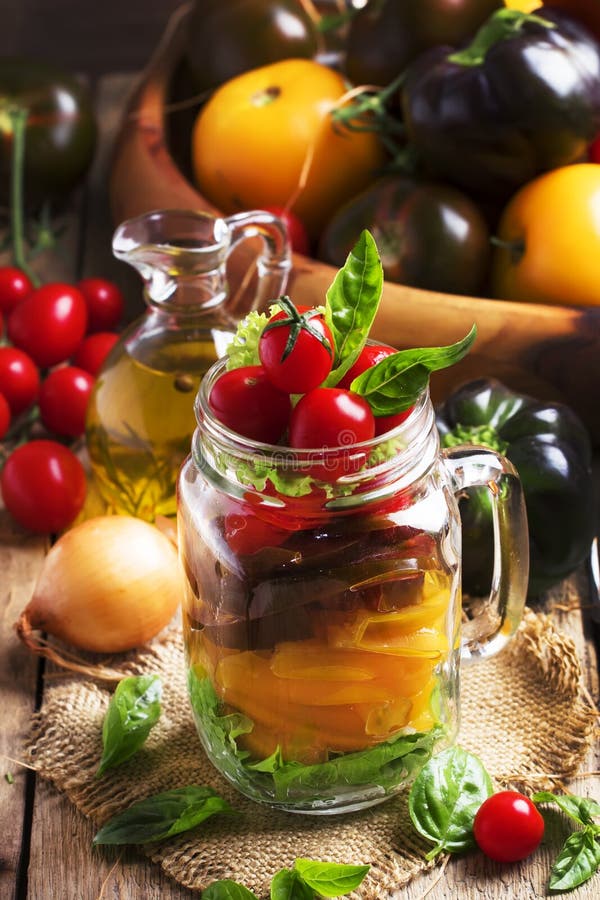 Salatglas des strengen Vegetariers mit den gelben, schwarzen und roten Kirschtomaten mit grünem Pfeffer, Zwiebeln, Kopfsalat, Bas stockbild Salatglas des strengen Vegetariers mit den gelben, schwarzen und roten Kirschtomaten mit grünem Pfeffer, Zwiebeln, Kopfsalat, Bas stockbild