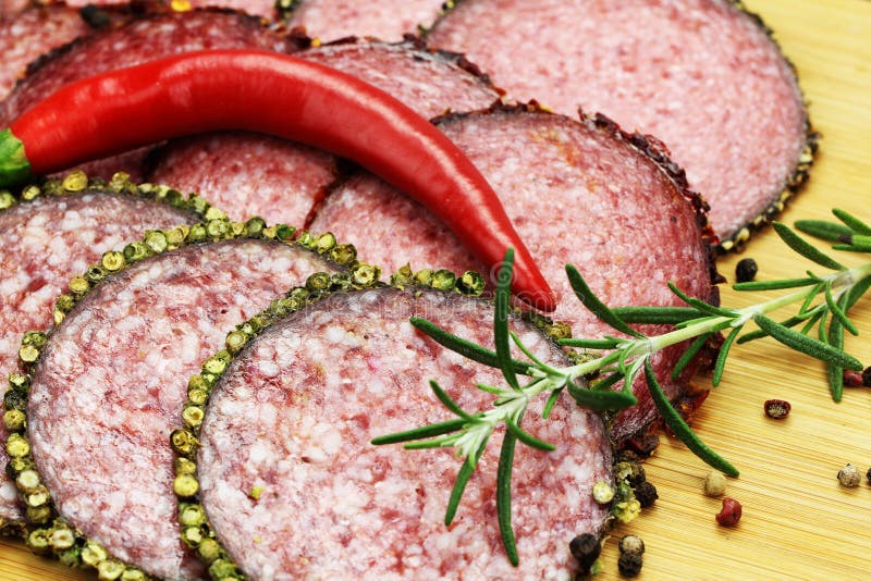 Salchicha O Salami Con Pimienta De Chile Con Las Hierbas En La Tabla De
