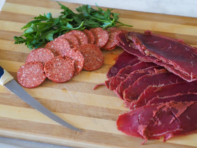 Salchicha y tocino turcos cortados en tabla de cortar Cuchillo, salchicha y tocino en la madera imágenes de archivo libres de regalías Salchicha y tocino turcos cortados en tabla de cortar Cuchillo, salchicha y tocino en la madera imágenes de archivo libres de regalías