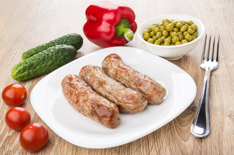 Salchichas asadas a la parrilla en la placa, pimienta dulce, pepinos, tomates, GR imagen de archivo Salchichas asadas a la parrilla en la placa, pimienta dulce, pepinos, tomates, GR imagen de archivo
