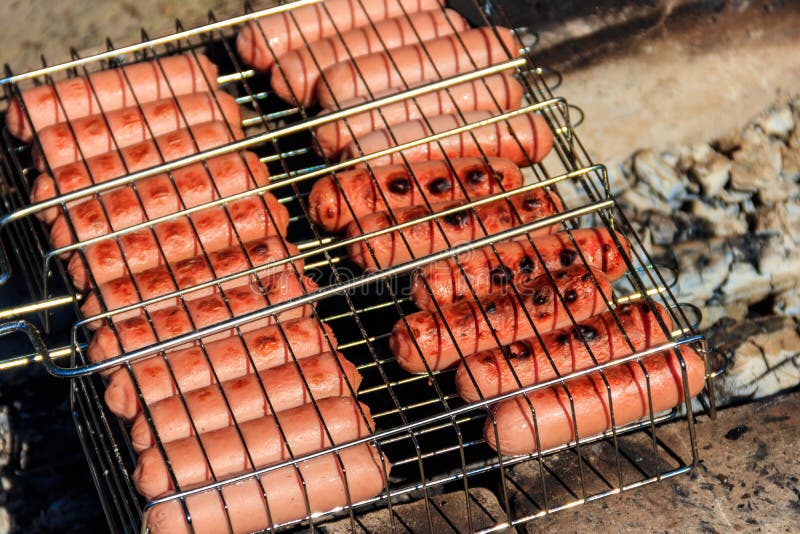 Salchichas de parrilladas en parrillada cocinando en fogones imágenes de archivo libres de regalías Salchichas de parrilladas en parrillada cocinando en fogones imágenes de archivo libres de regalías