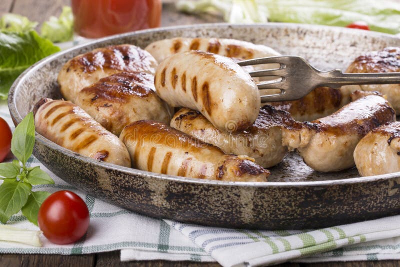 Salchichas y hamburguesas asadas a la parrilla del pollo imagenes de archivo Salchichas y hamburguesas asadas a la parrilla del pollo imagenes de archivo