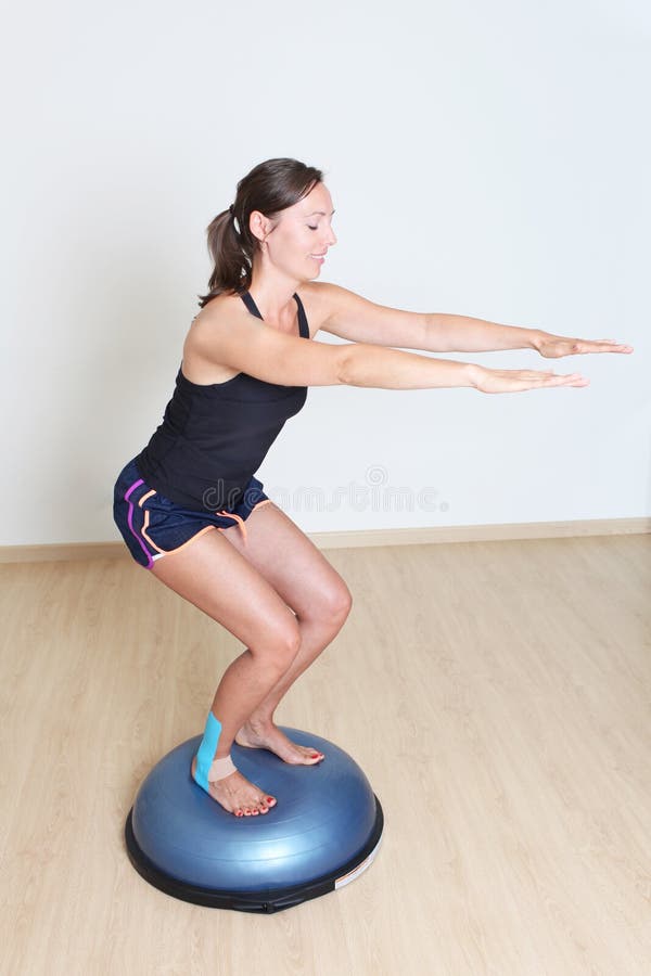 Woman making a balance exercise on both sides ball. Woman making a balance exercise on both sides ball