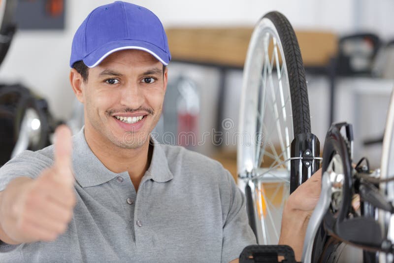 Salesman in Bicycle Shop Showing Thumb Up Stock Photo Image of