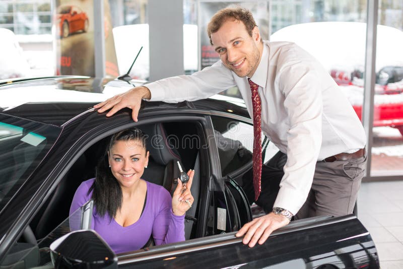 Salesman selling a car to happy customer