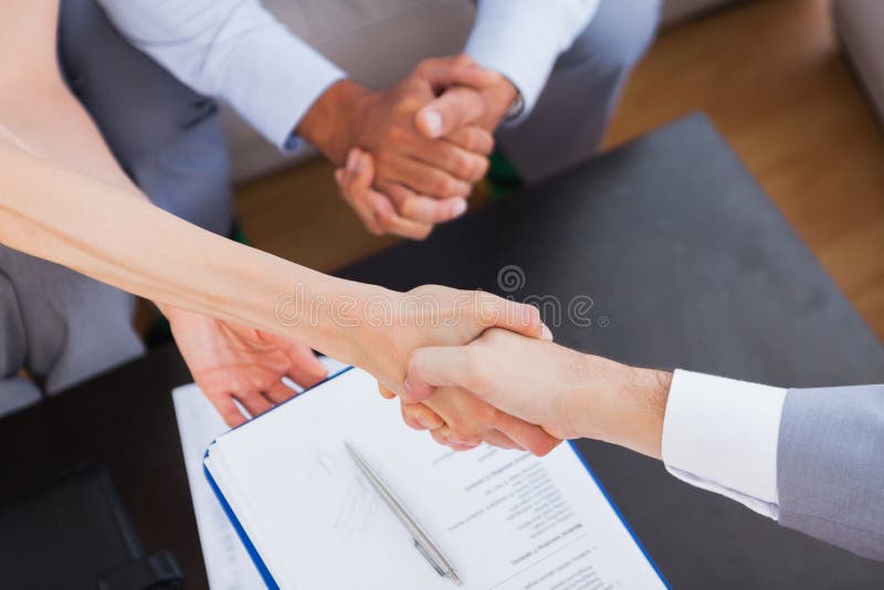 Salesman shaking hand with client with contract on the coffee table. Negotiating table stock images, royalty-free photos and pictures