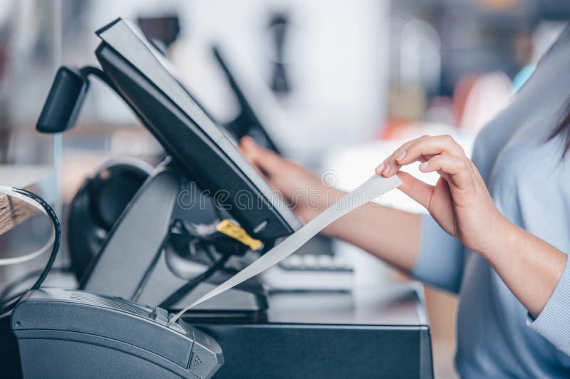 Saleswoman printing invoice or receipt for a customer in the shopping center, POS system