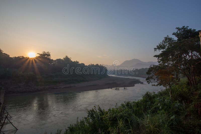 Salida del sol con los rayos de oro sobre el río de Luang Prabang imágenes de archivo libres de regalías Salida del sol con los rayos de oro sobre el río de Luang Prabang imágenes de archivo libres de regalías