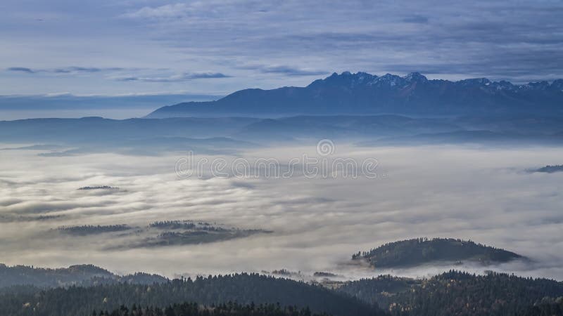 Salida del sol en las montañas de Tatra con las nubes que fluyen, Polonia