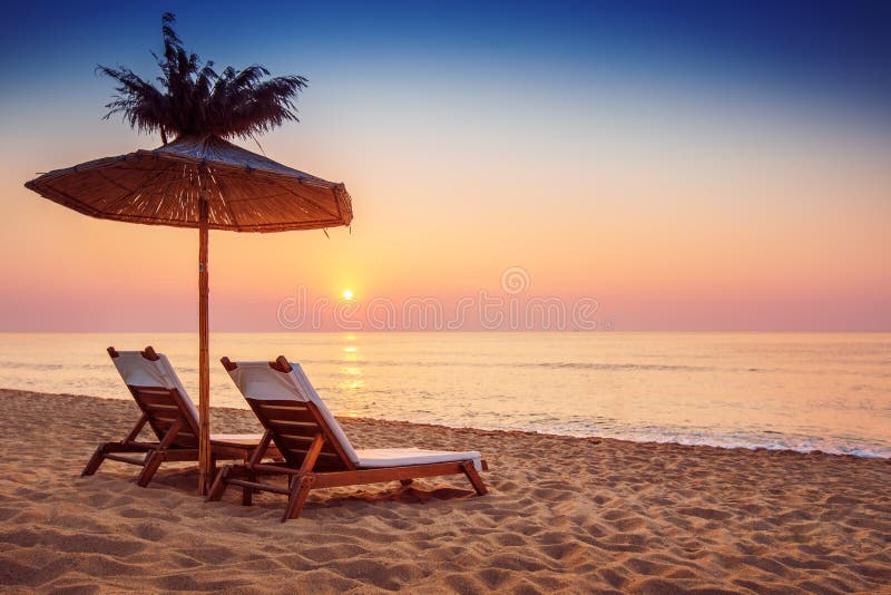 Vivid sunrise on a beautiful sandy beach with sunshade. Vivid sunrise on a beautiful sandy beach with sunshade