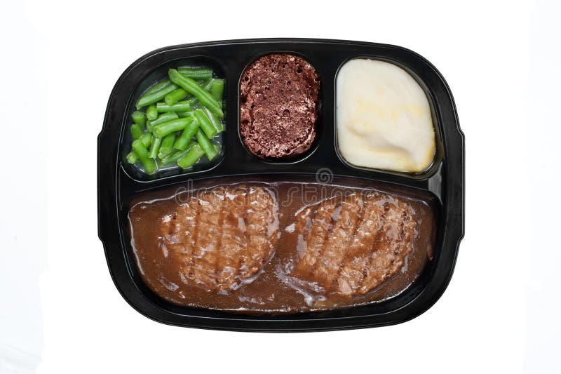 An unhealthy Salisbury steak TV dinner with gravy, mashed potatoes and a brownie dessert in a plastic tray isolated on white. Dessert portions stock images, royalty-free photos and pictures