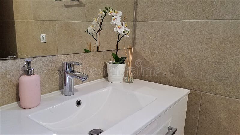 Salle de bains moderne dans des tons beiges avec des accents roses photos stock Salle de bains moderne dans des tons beiges avec des accents roses photos stock