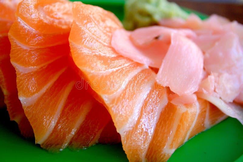 A plate of salmon sashimi - sushi with pickled ginger and wasabi