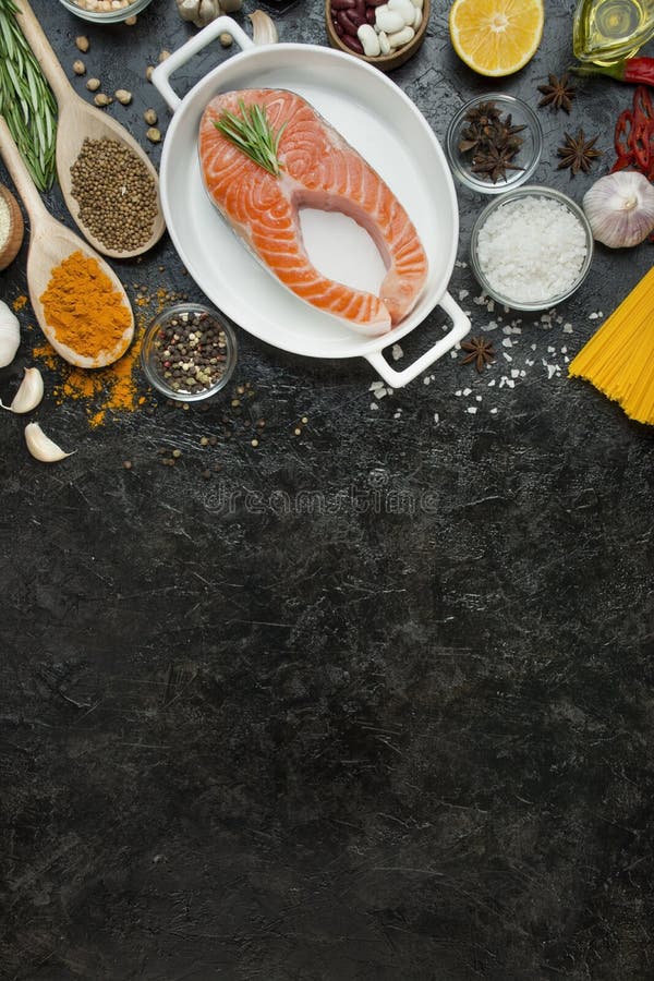 Salmon fillet with aromatic herbs, spices, Italian pasta and vegetables on a dark background. Cooking concept. Culinary background royalty free stock images Salmon fillet with aromatic herbs, spices, Italian pasta and vegetables on a dark background. Cooking concept. Culinary background royalty free stock images