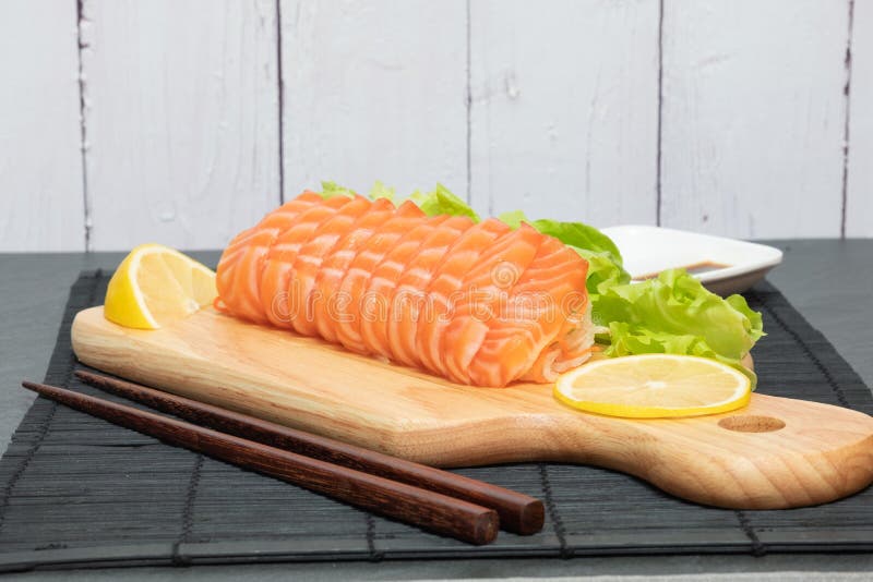 Salmon Fish Sliced on Wood Cutting Board with Vegetable Stock Photo
