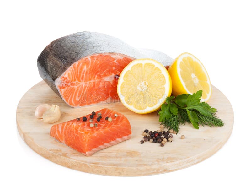 Salmon with herbs and lemon slices on cutting board