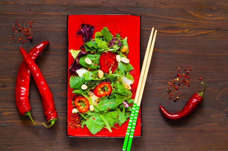 Salmon Poke Salad en la placa roja con los palillos en fondo, concepto del alimento biológico, la comida del detox o el concepto imagenes de archivo Salmon Poke Salad en la placa roja con los palillos en fondo, concepto del alimento biológico, la comida del detox o el concepto imagenes de archivo