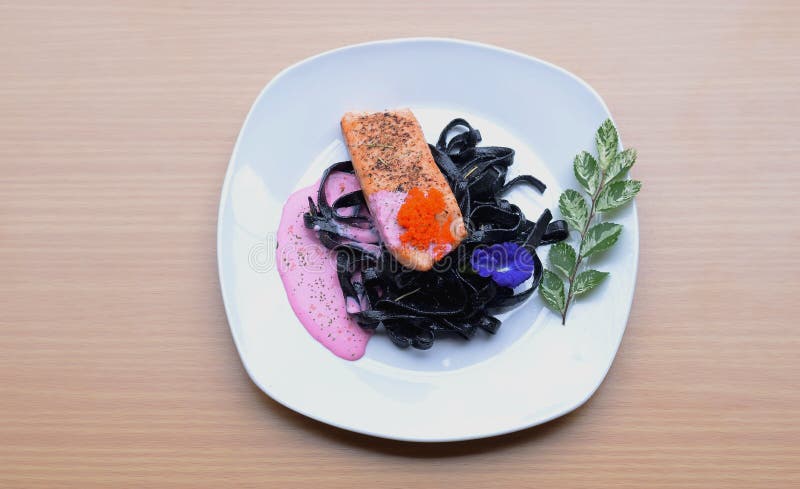 Salmon стейк при соус бураков макаронных изделий чернил кальмара cream жаря tobiko косуль рыб стоковое фото Salmon стейк при соус бураков макаронных изделий чернил кальмара cream жаря tobiko косуль рыб стоковое фото