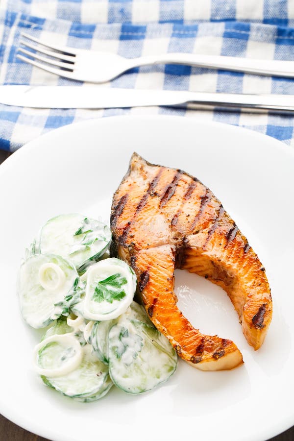 Salmone arrostito con l'insalata del cetriolo fotografia stock libera da diritti Salmone arrostito con l'insalata del cetriolo fotografia stock libera da diritti