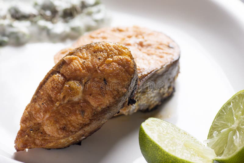 Salmones asados a la parrilla con el limón y la ensalada fotografía de archivo Salmones asados a la parrilla con el limón y la ensalada fotografía de archivo