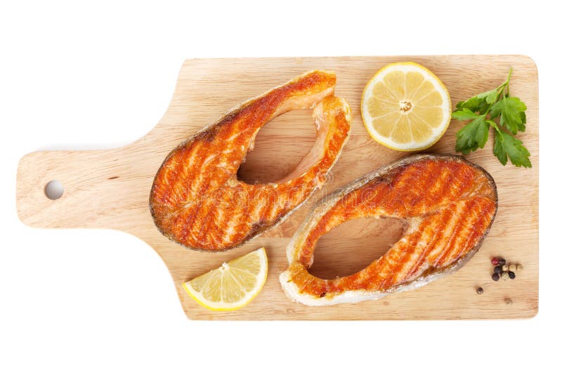 Salmones asados a la parrilla con las rebanadas del lim?n e hierbas en tabla de cortar imagen de archivo Salmones asados a la parrilla con las rebanadas del lim?n e hierbas en tabla de cortar imagen de archivo
