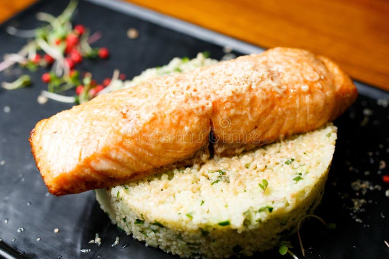Salmones asados a la parrilla con gras, cuscús y el pepino del foie del hígado en el arroz blanco foto de archivo Salmones asados a la parrilla con gras, cuscús y el pepino del foie del hígado en el arroz blanco foto de archivo