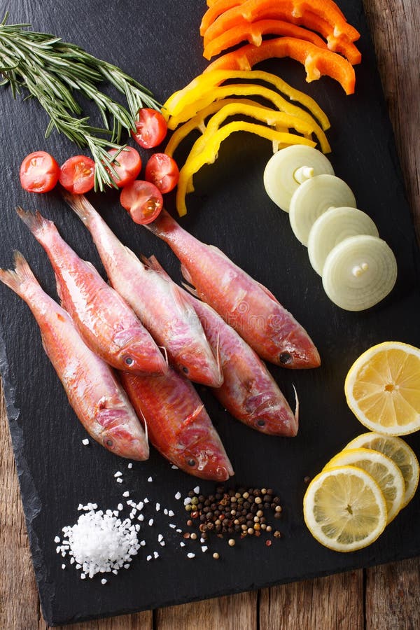 Salmonete vermelho de peixes crus com vegetais e close-up do limão no ki fotos de stock Salmonete vermelho de peixes crus com vegetais e close-up do limão no ki fotos de stock
