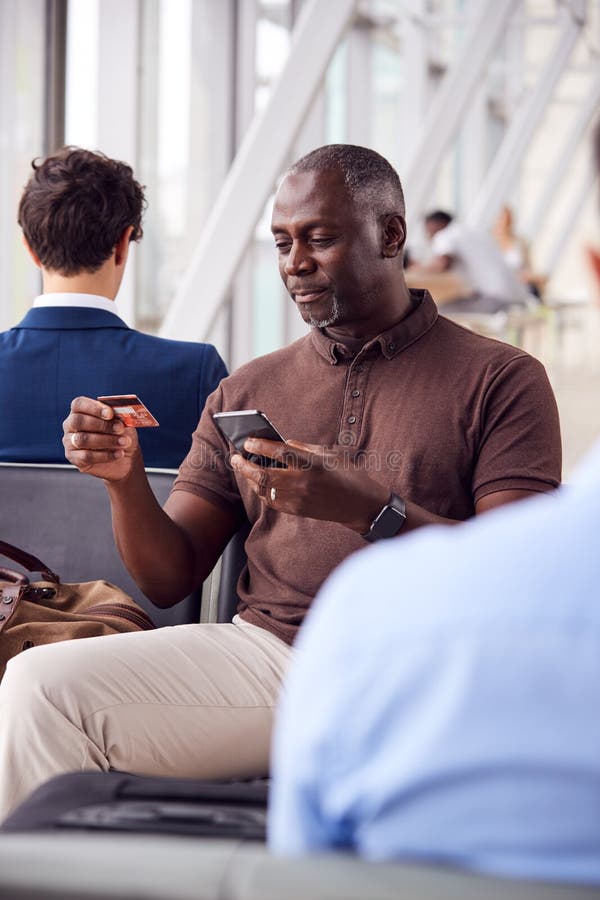 Salon de départ de Sitting In Airport d'homme d'affaires qui font des achats en ligne en utilisant le téléphone portable
