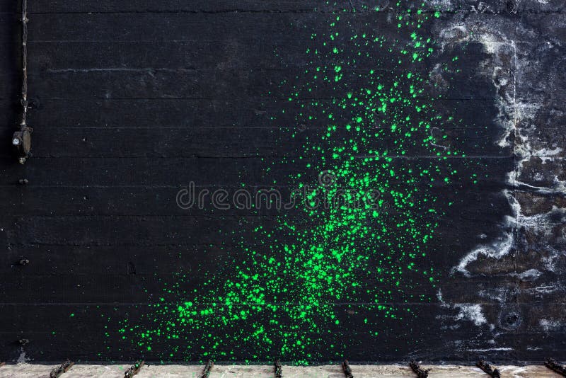 Salpicadura verde del dolor en el muro de cemento negro imagen de archivo libre de regalías Salpicadura verde del dolor en el muro de cemento negro imagen de archivo libre de regalías