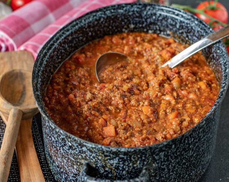 Fresh and homemade cooked bolognese sauce in a big pot with ladle. original italian  recipe. Served hot on a table and ready to eat. Italian family meal. Fresh and homemade cooked bolognese sauce in a big pot with ladle. original italian  recipe. Served hot on a table and ready to eat. Italian family meal